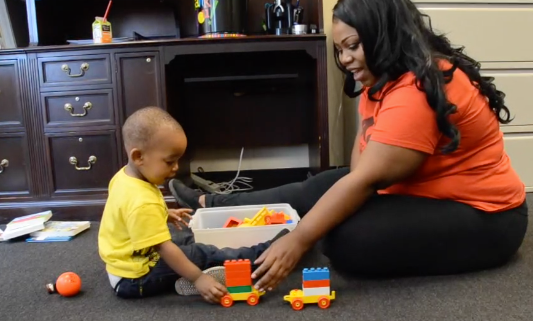 Mother and toddler playing with building blocks together